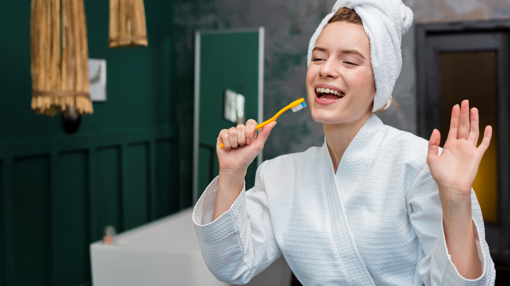 woman bathrobe playing around with toothbrush 1 edited