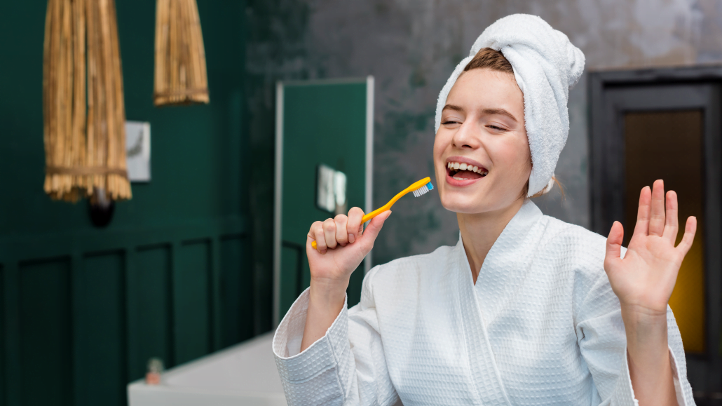 woman bathrobe playing around with toothbrush edited